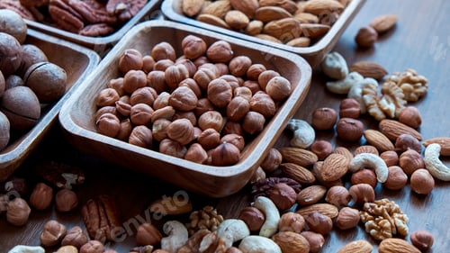 Preview: Wooden bowl with mixed nuts on table top view. Healthy food and snack