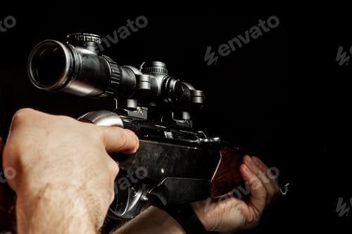 Preview: Male hands holding hunting rifle on black background