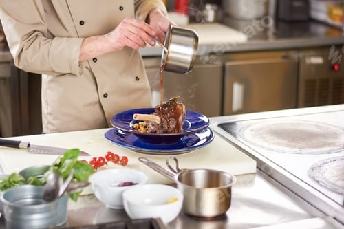 Preview: Chef pouring sauce on lamb shank