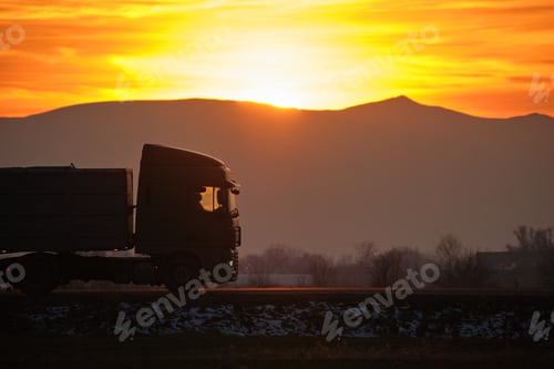 Preview: Semi-truck with cargo trailer driving on highway hauling goods in evening. Delivery transportation