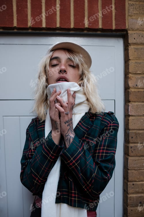 Preview: Tattoo alternative posing in front of the camera with closed eyes.