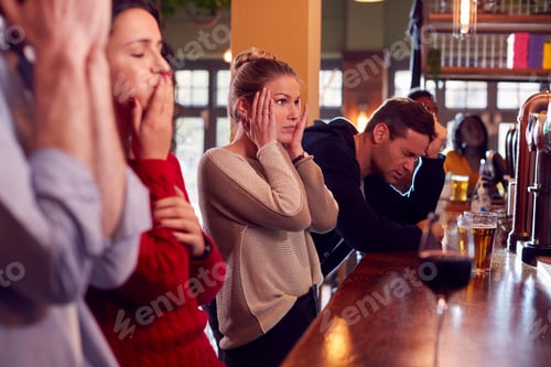 Preview: Group Of Disappointed Customers In Sports Bar Watching Sporting Event On Television