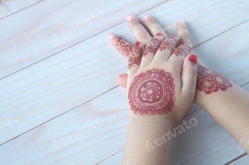 Preview: child girl hand with mehendi on table,