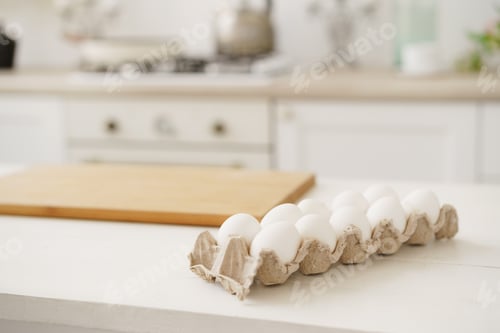 Preview: Eggs in egg box on white wooden table in kitchen