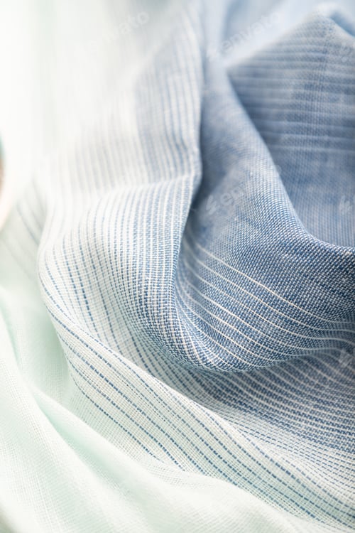 Preview: Fragment of blue and white linen tissue. Side view, textile background and texture.