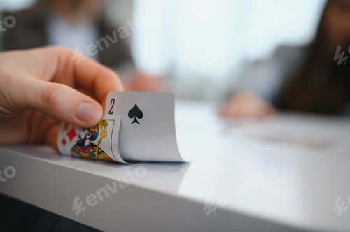 Preview: Friends playing cards, revealing the two of spades in a friendly game