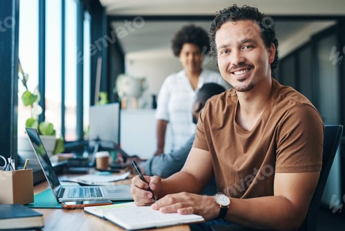 Preview: Shot of a young businessman writing in a notebook in an office