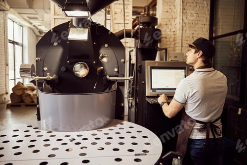 Preview: Professional male roaster using industrial coffee roasting machine
