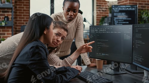 Preview: Programer pointing at computer screen explaining running code to coworkers brainstorming software