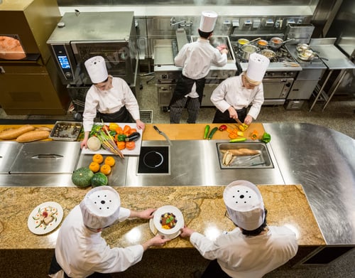 Preview: A view looking down on a crew of chefs working in a commercial kitchen,