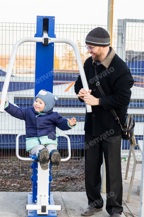 Preview: Dad rolls his daughter on a swing, they have fun and play in the city park