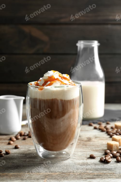 Preview: Glass of coffee with caramel topping on wooden table