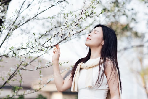 Preview: Candid lifestyle portrait of happy young Asian woman with brunette hair smiling outdoor at spring