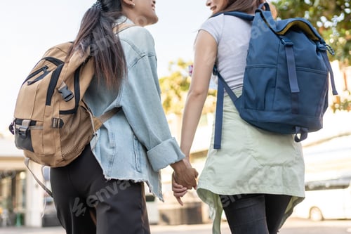 Preview: Close up of two women backpacker hold hand while travel outdoors in city.