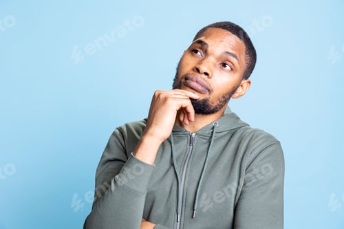 Preview: Thoughtful unsure guy with a grey hoodie contemplating about new ideas