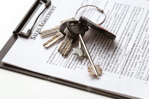 Preview: Sales agreement and keys on a clipboard for property transaction at a real estate office