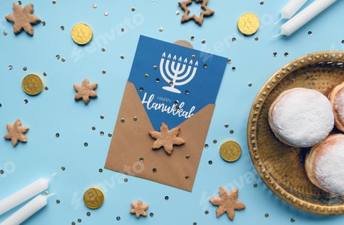 Preview: Blue hanukkah flat lay with donuts and white candles around a holiday card.