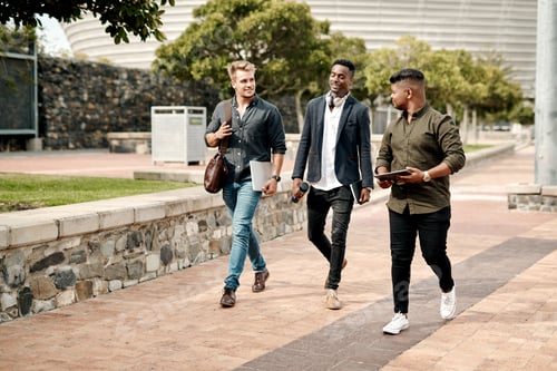 Preview: Shot of a group of young businesspeople chatting while walking through the city