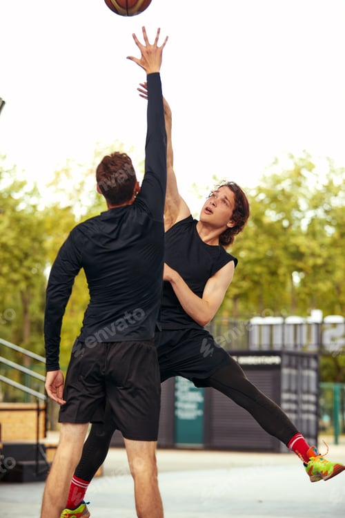 Preview: Young guys playing basketball, posing for the camera on the city basketball court, lifestyle active