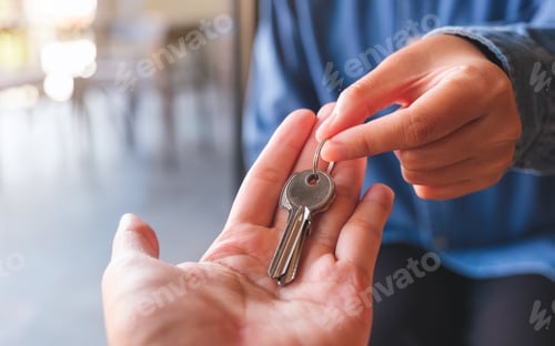 Preview: Closeup image of a real estate agent giving the keys to owner or buyer