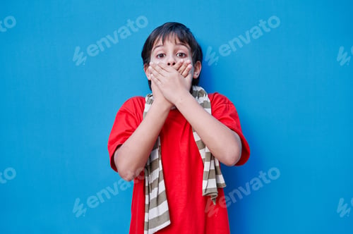 Preview: A Portrait of boy with surprised face in red t-shirt, on blue background. Copy space