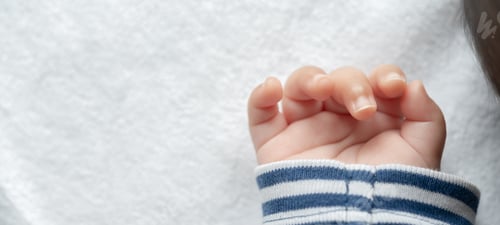 Preview: Newborn baby hand in white bed