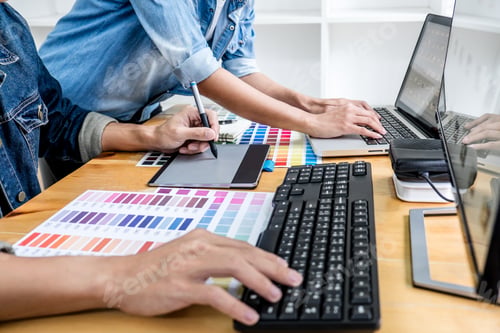 Preview: Two colleagues creative graphic designer working on color selection and drawing on graphics tablet