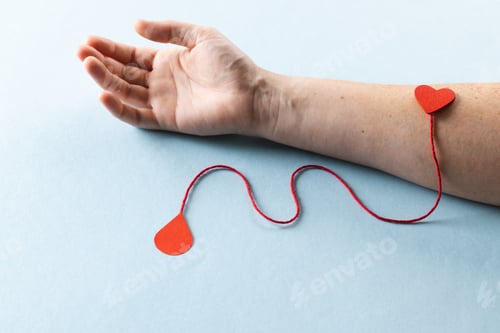 Preview: Arm of caucasian woman with heart and red string with blood drop, on blue background