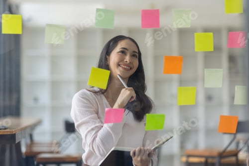 Preview: Business female employee with many conflicting priorities arranging sticky notes commenting and brai