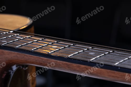 Preview: Close-up of strings on the fretboard of an acoustic guitar.