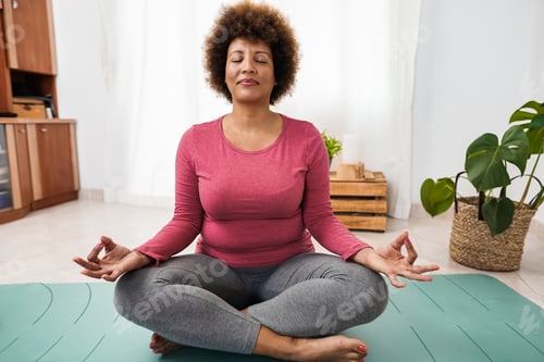 Preview: African senior woman doing yoga session at home - Focus on face