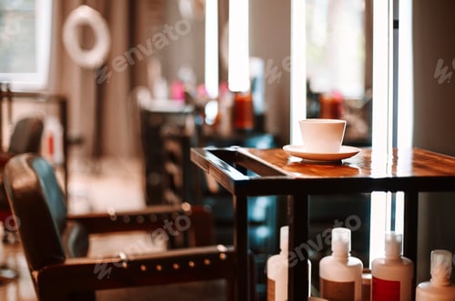 Preview: Coffee cup on wooden table and chair for client in empty hairdresser salon