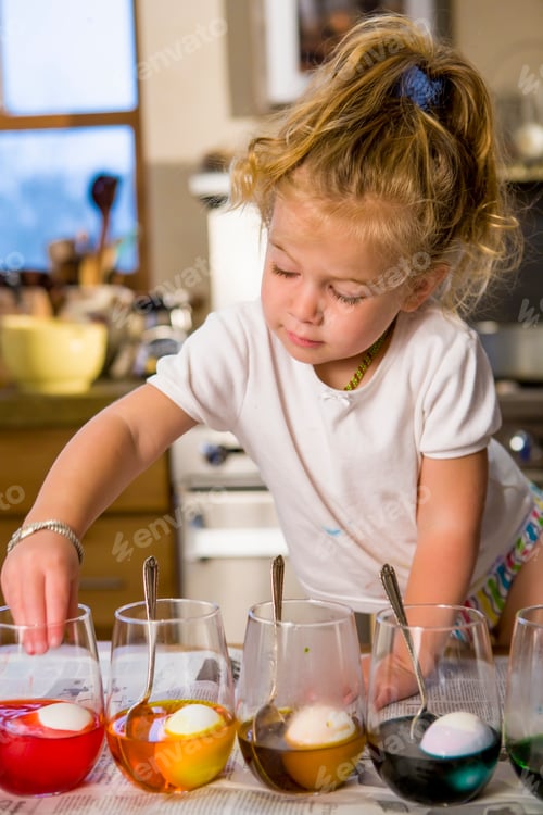 Preview: 3 year old girl coloring easter eggs at home with her mother