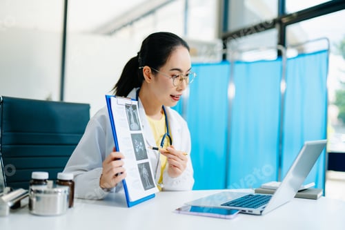 Preview: Asian female doctor showing X-ray report on clipboard during online consultation. Concept