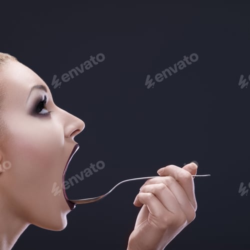 Preview: Open wide. Shot of a woman holding a spoon with her mouth wide open.