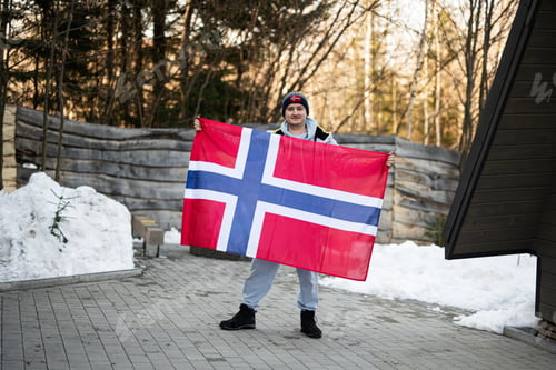 Preview: Portrait of man holding Norway flag. Scandinavian culture, norwegian people.