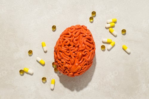 Preview: Orange human brain model with pills and vitamins