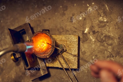 Preview: Professional goldsmith holding a blowlamp over the crucible