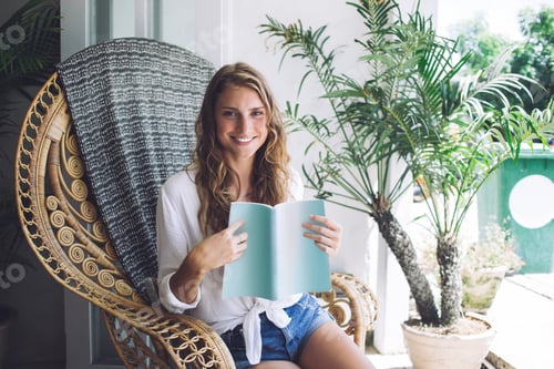 Visualização: Mulher alegre rindo de livro engraçado