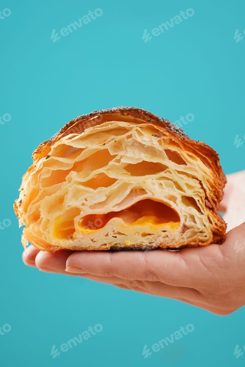 Preview: Holds freshly baked cut croissant on bright colorful background