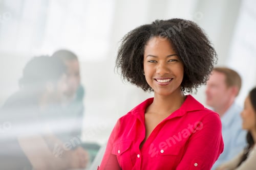 Preview: An office in the city. A group sitting down around a table. One business woman in the foreground.