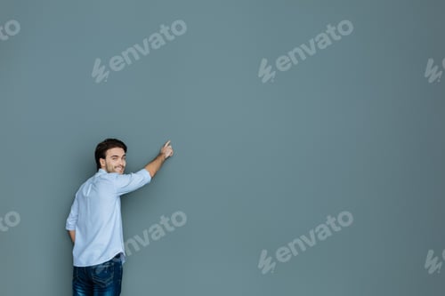 Preview: Friendly Smile. Delighted Cheerful Nice Man Turning To You And Smiling While Writing On The Wall
