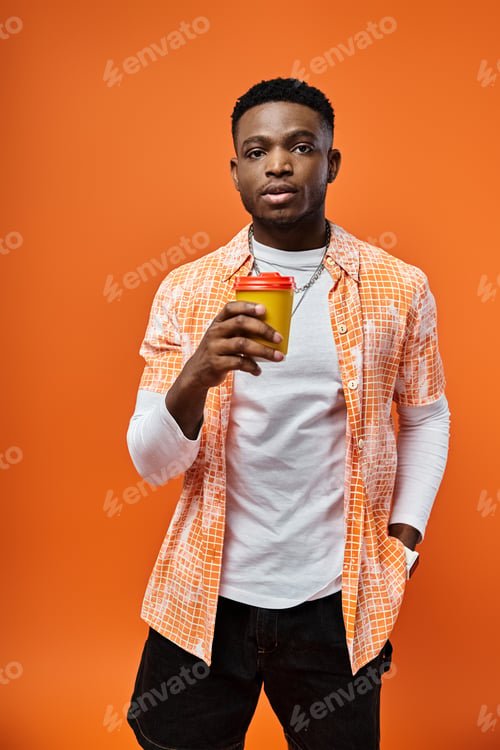 Preview: Stylish Man Enjoying Coffee on Vibrant Orange Background