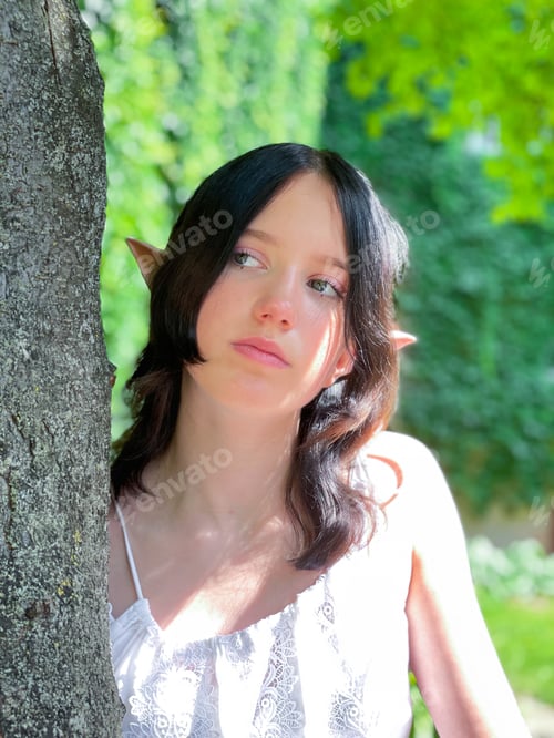 Preview: Beautiful teenager girl with Forest Elve ears in white dress in fairytale green place