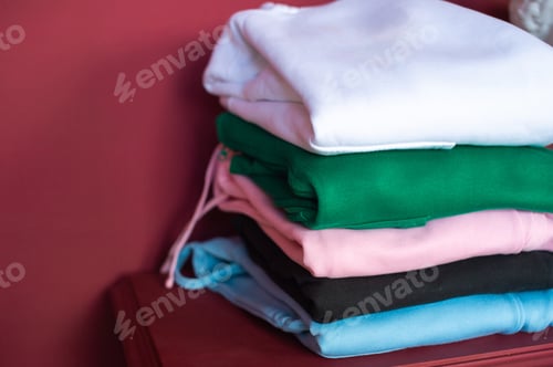 Preview: on the table are neatly folded hoodies in the interior, a model of hoodies in different colors