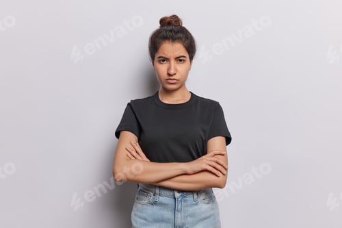 Vista previa: Serious offended woman adopts closed posture with folded arms exuding air of discontent frowns face