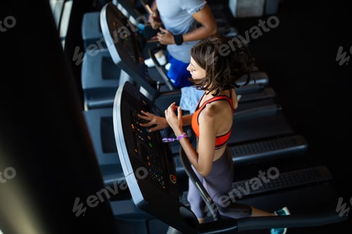 Preview: Group of young people running on treadmills in modern sport gym