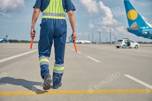 Preview: Caucasian airport worker heading towards an airplane