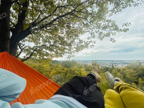 Preview: couple laying down in hammock relaxing enjoying warm autumn day