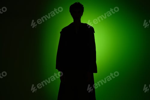 Preview: Captivating silhouette of a stylish young man against a vibrant green backdrop